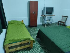 Un dormitorio con una cama, un televisor y una silla. en Jorge 1, en Marcos Juárez
