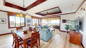 a living room with a table and a blue couch at ❤PiH❤ Endless Ocean Views Villa Gorgeous Mauna Kea Ocean and Mountain View in Hapuna Beach