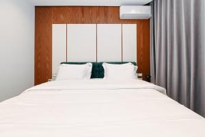 a bedroom with a large bed with white sheets at Wilson On The Bllok in Tirana
