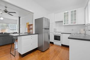 a kitchen with white cabinets and a stainless steel refrigerator at Seascape On Cairnes in Indented Head