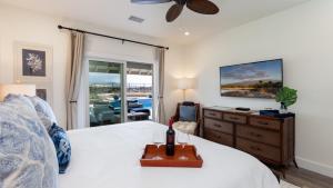 ein Schlafzimmer mit einem Bett mit einer Flasche Wein darauf in der Unterkunft ALOHA SPIRIT AinaMalu 4BR Home with Outdoor Living Room and Pool in Waikoloa + 59 Fotos