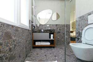 a bathroom with a toilet and a sink at Wilson On The Bllok in Tirana +15 photos