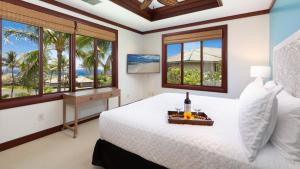 a bedroom with a bed and a desk and windows at ❤PiH❤ A Sea-nic Escape Stunning Ocean View Mauna Kea Resort eBikes in Hapuna Beach +61 photos