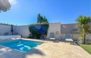 a backyard with a swimming pool and two chairs at Nice Home In Cabannes in Cabannes
