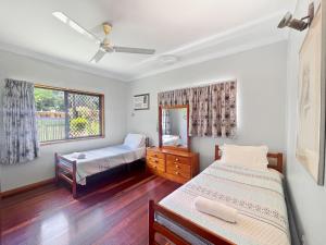 a bedroom with two beds and a window at Arcadia Gardens in Arcadia