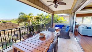 a porch with a wooden table and chairs at HAWAIIAN DESTINY Spacious Detached KaMilo 4BR with Heated Pool and Spa in Waikoloa