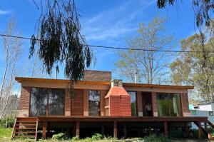 a house with a brick chimney on top of it at Village De Las Sierras in Sierra de la Ventana