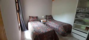 シエラ・デ・ラ・ベンターナにあるVillage De Las Sierrasのベッドルーム1室(ベッド2台、ランプ付きテーブル付)