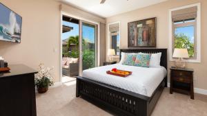 een slaapkamer met een bed met een dienblad erop bij WAHI MALU Comfortable 3BR Single-Level KaMilo Home Near Pool in Waikoloa +46 foto's
