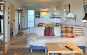 a living room with a couch and a table at Awesome Apartment In Hals With House A Panoramic View in Skovsgård