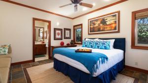a bedroom with a bed with a blue comforter at ❤PiH❤ Hale Kanani Hilton Resort PassesFully Detached HomeBeach Gear Bikes in Waikoloa +63 photos