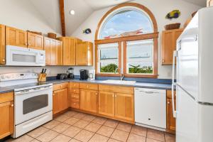 a kitchen with wooden cabinets and a window at 8198 - Still Waters in Waves