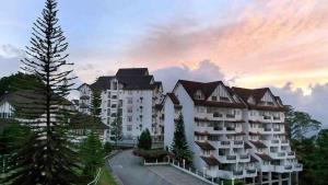 フレイザーズ・ヒルにあるComfyHome A3-5-6 5th Flr Mountaon viewの夕日を背景にした大きなアパート