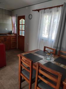 a dining room table with two chairs and a kitchen at Cabaña el Encanto in Villarrica