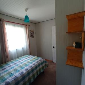 a bedroom with a bed and a window at Cabaña el Encanto in Villarrica