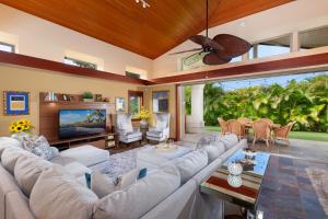 a living room with a large couch and a tv at PiH: Aloha Palms~ Fully Detached Home Beach Gear Bikes in Waikoloa