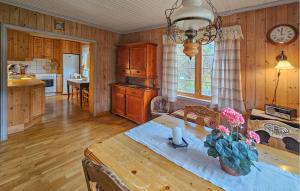 a kitchen and dining room with a table with flowers on it at Beautiful Home In Dalen With Harbor View in Dalen