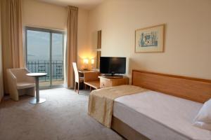 a hotel room with a bed and a television at Hotel Jadran in Rijeka