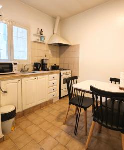 een keuken met een tafel en stoelen en een fornuis bij Delakay alojamientos 3 in Godoy Cruz