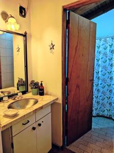 een badkamer met een wastafel en een houten deur bij Delakay alojamientos 3 in Godoy Cruz