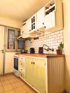 een keuken met witte kasten en een spoelbak bij Delakay alojamientos 3 in Godoy Cruz