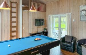 a living room with a pool table and a tv at Amazing Home In Væggerløse With Sauna in Marielyst