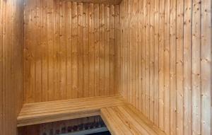 a corner of a sauna with a wooden wall at Amazing Home In Væggerløse With Sauna in Marielyst +10 photos