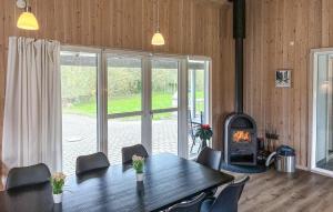 a dining room with a table and a fireplace at Amazing Home In Væggerløse With Sauna in Marielyst
