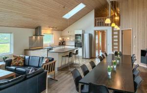 a kitchen and living room with a table and chairs at Amazing Home In Væggerløse With Sauna in Marielyst