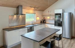 a large kitchen with white cabinets and a counter top at Amazing Home In Væggerløse With Sauna in Marielyst