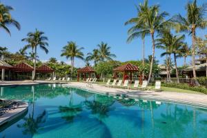 a swimming pool at a resort with palm trees at ❤PiH❤ Hono Loa BikesBeach Toys Private Beach Club in Waikoloa