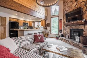 a living room with a couch and a stone fireplace at Spacious 3BD & Loft Villa - Convenient to Slopes in Mammoth Lakes