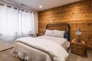 a bedroom with two beds and a wooden wall at Spacious 3BD & Loft Villa - Convenient to Slopes in Mammoth Lakes