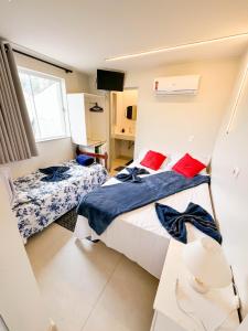 a small bedroom with two beds and a window at CASA HOTEL PIRACICABA in Piracicaba