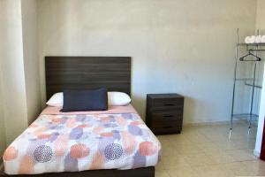 ein Schlafzimmer mit einem Bett mit einem hölzernen Kopfteil in der Unterkunft departamento plus 1917 in Zacatlán + 3 Fotos