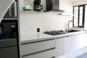 eine weiße Küche mit Spüle und Herd in der Unterkunft departamento plus 1917 in Zacatlán