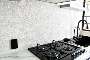 a stove top oven in a kitchen next to a wall at departamento plus 1917 in Zacatlán