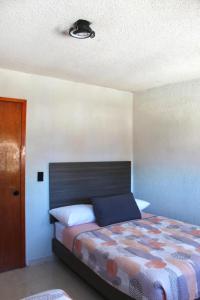 ein Schlafzimmer mit einem Bett und einer Decke in der Unterkunft departamento plus 1917 in Zacatlán