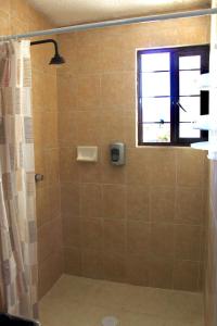 ein Bad mit einer Dusche und einem Fenster in der Unterkunft departamento plus 1917 in Zacatlán
