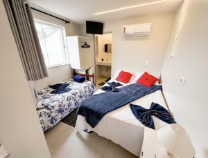 a bedroom with two beds with blue and red pillows at CASA HOTEL PIRACICABA in Piracicaba +151 photos