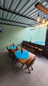 a dining room with a table and a large screen at CASA HOTEL PIRACICABA in Piracicaba