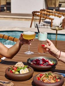 two people holding drinks and plates of food on a table at Villa in and Home in Mardakan