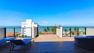 a balcony with chairs and a view of the ocean at Maré Alta Beach Hall - Praia de Tamandaré in Praia dos Carneiros