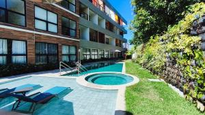 a swimming pool in front of a building at Maré Alta Beach Hall - Praia de Tamandaré in Praia dos Carneiros