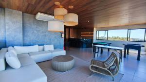 a living room with a white couch and a table at Maré Alta Beach Hall - Praia de Tamandaré in Praia dos Carneiros