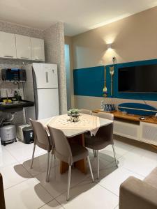 a kitchen with a table and chairs and a refrigerator at Hospedagem em frente a praia in Salinópolis