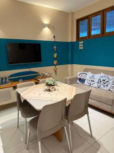 a living room with a table and chairs and a couch at Hospedagem em frente a praia in Salinópolis