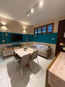 a living room with a table and a couch at Hospedagem em frente a praia in Salinópolis