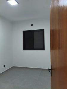 a white room with a television on a wall at Peruíbe nova in Peruíbe