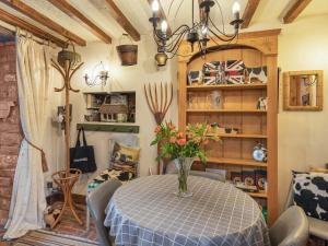 a dining room with a table with a vase of flowers at The Cowshed in Penrith